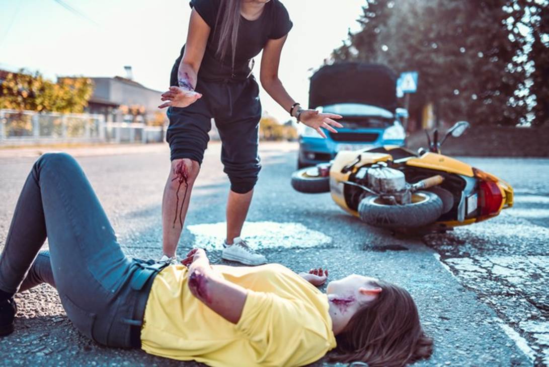 A person standing next to a person lying on the ground with a motorcycle

AI-generated content may be incorrect.